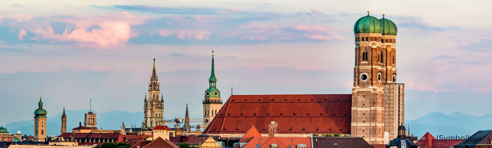 Skyline von München mit Frauenkirche, Rathaus und Kirchtürmen bei Abendhimmel