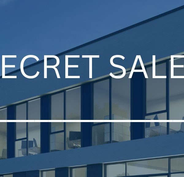 Modernes Geschäftshaus mit "Secret Sale"-Schriftzug