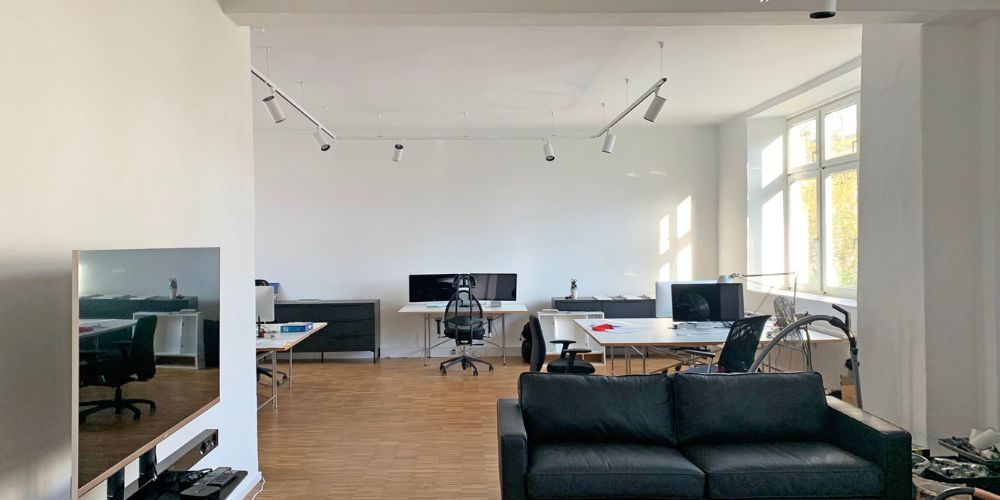 Helles, modernes Büro in München mit großen Fenstern, mehreren Arbeitsplätze