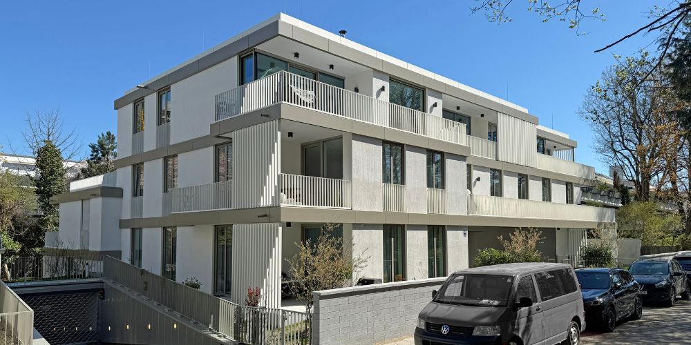 Modernes Mehrfamilienhaus mit klarer Architektur, Balkonbauten und eleganter Fassade in einer ruhigen Wohngegend