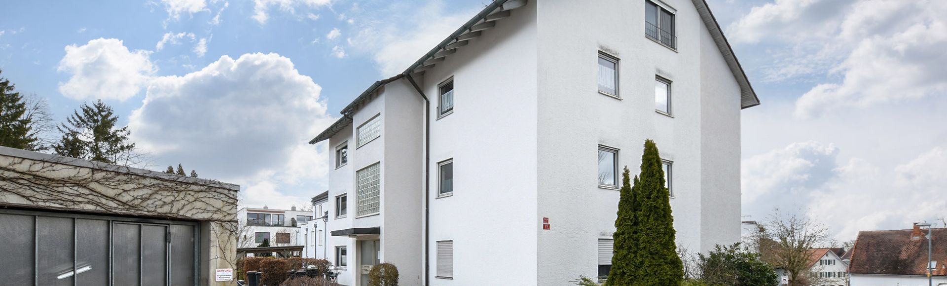 Modernes Mehrfamilienhaus in München mit gepflegter Außenanlage, Stellplätzen und ruhiger Wohnstraße in gewachsener Wohngegend