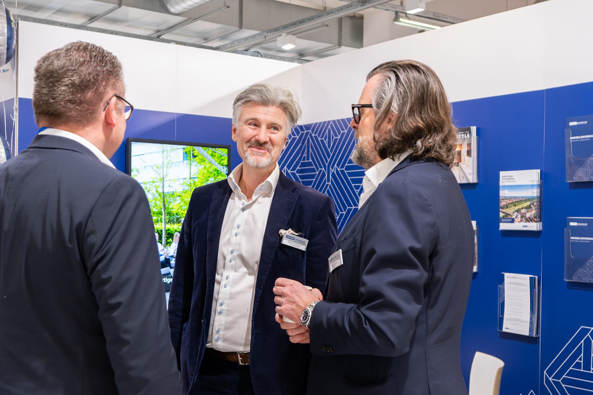 Mehrere Immobilienmakler im Gespräch auf der Münchner Immobilienmesse