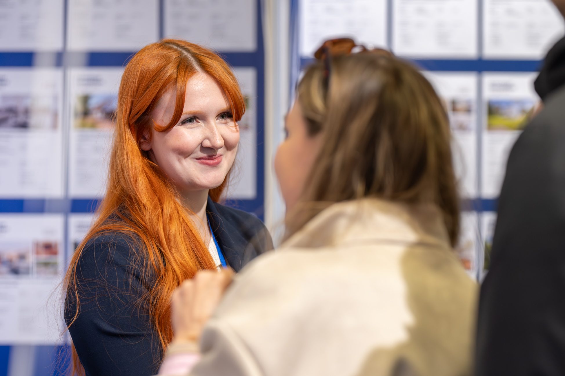 Immobilienmaklerin bei der Beratung am Messestand