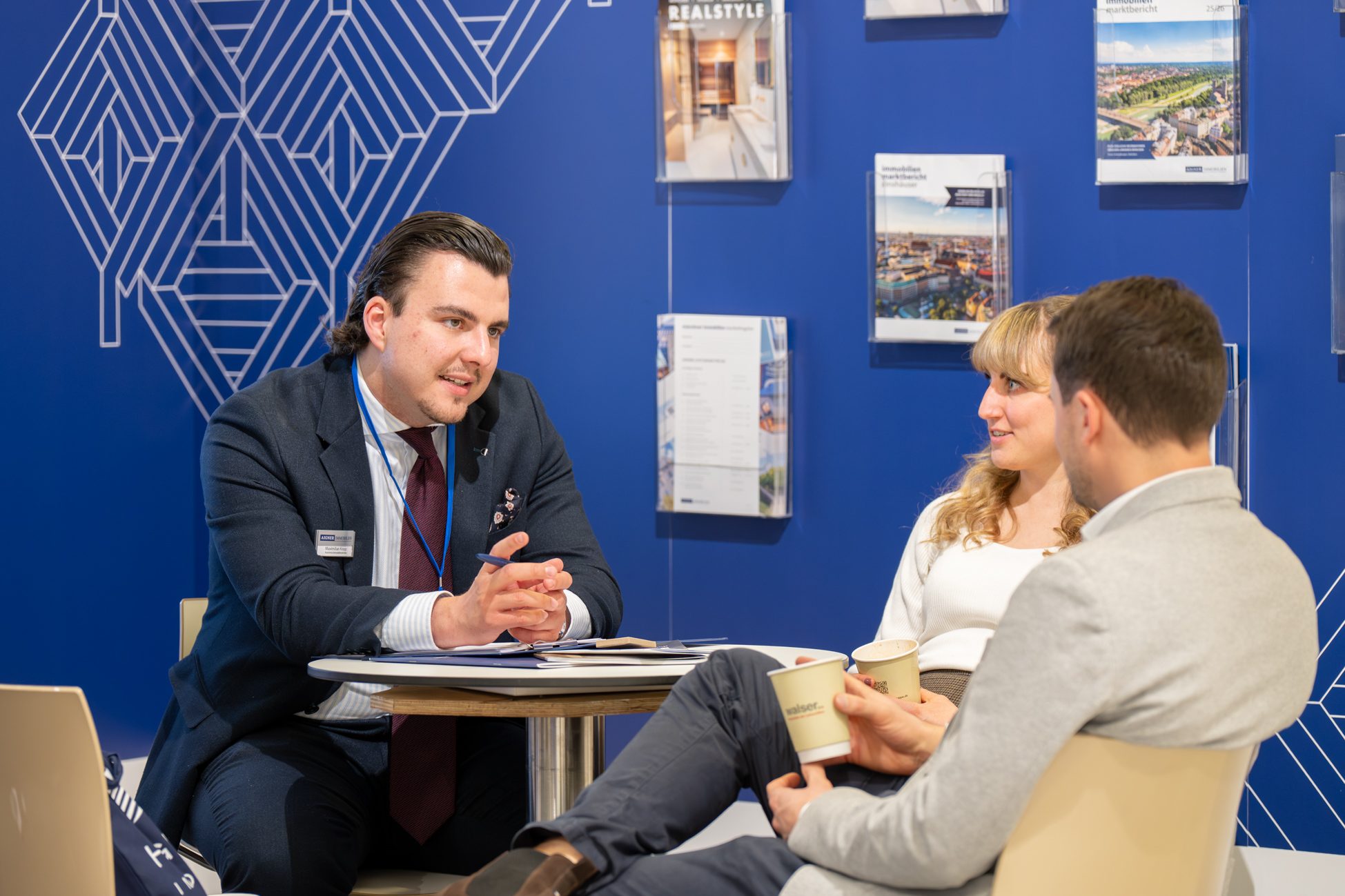 Immobilienmakler in der Kundenberatung am Messestand