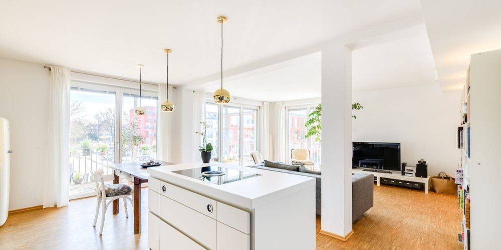 Exklusive Immobilie mit offenem Wohnbereich und Designküche (31187) Moderner, lichtdurchfluteter Wohn- und Essbereich mit offener Designküche, bodentiefen Fenstern, hochwertigem Parkettboden und Zugang zum Balkon