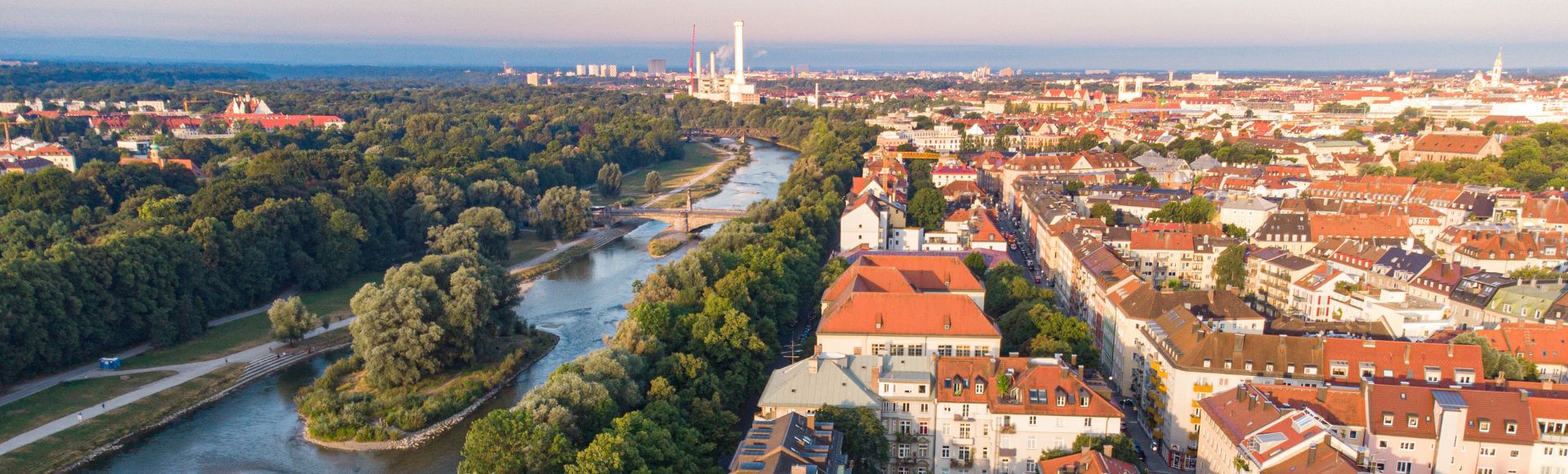 Luftaufnahme der Isar mit grünen Uferanlagen und Wohngebäuden in München nahe der Altstadt und beliebten Wohnlagen an der Isar