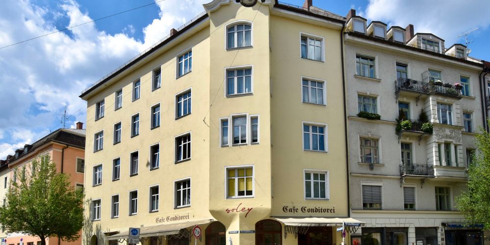Außenansicht eines Mehrfamilienhauses mit Café im Erdgeschoss an einer Straßenecke in München