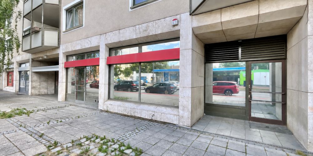 Außenansicht einer Gewerbeeinheit mit großer Schaufensterfront und Eingang im Erdgeschoss eines Mehrfamilienhauses in München