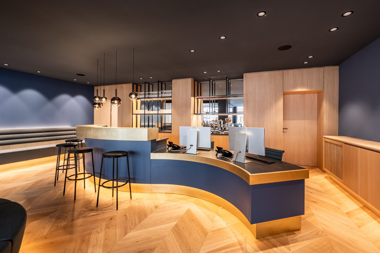 Eleganter Empfangsbereich mit geschwungener Empfangstheke, Sitzgelegenheiten und hochwertiger Innenarchitektur im Immobilienbüro in Schwabing