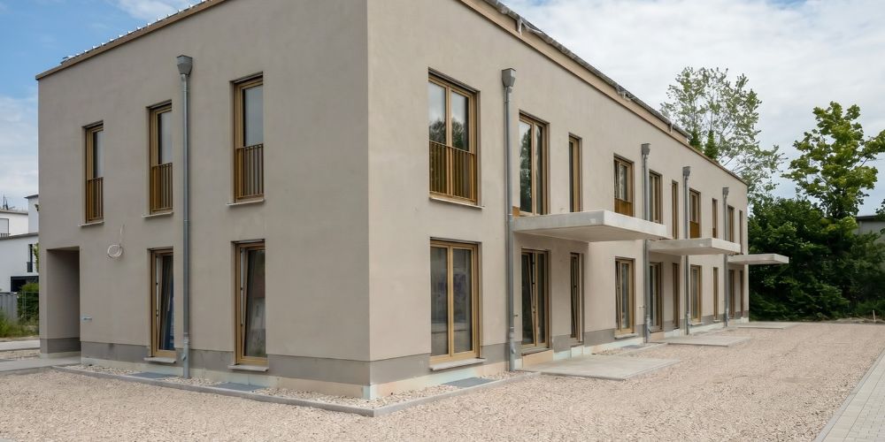 Neubau Mehrfamilienhaus mit heller Fassade und modernen Balkonen in München vor der Fertigstellung