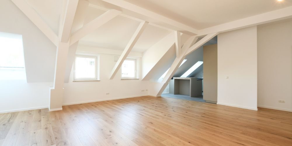 Heller Dachgeschoss-Wohnbereich mit sichtbaren Holzbalken und moderner Ausstattung München