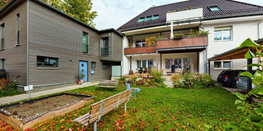 Mehrfamilienhaus mit Balkonen, gepflegtem Garten, Sandkasten und Sitzbank in München