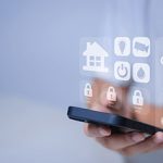 Eine Person bedient ein Handy mit Smart-Home-App