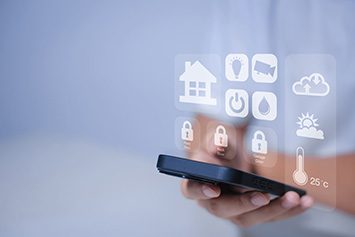 Eine Person bedient ein Handy mit Smart-Home-App