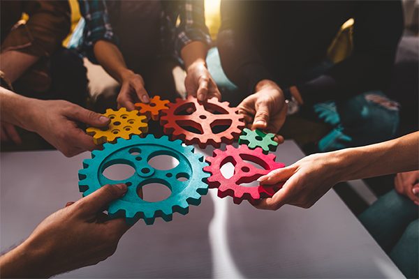 Teamwork of business people work together and combine pieces of gears Wohnung verkaufen Karlsruhe