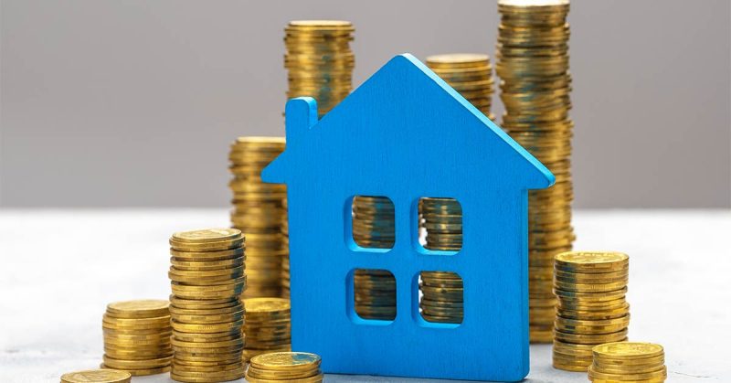 Blauen Haus und Geld das eine Mieterhöhung symbolisiert