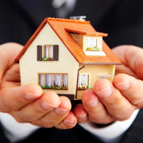 Ein Model eines Hauses wird in der Hand gehalten