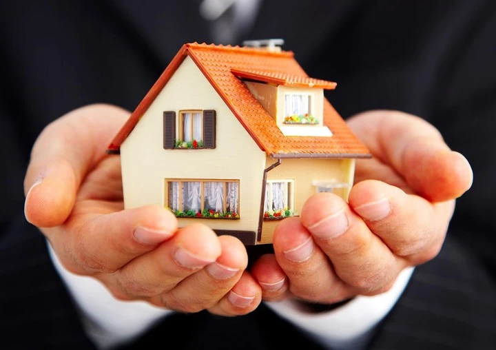 Ein Model eines Hauses wird in der Hand gehalten