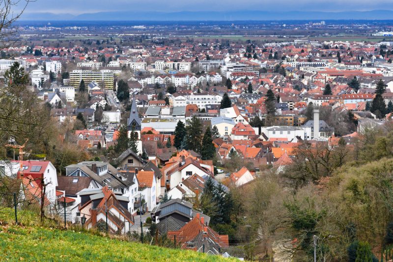 Blick auf das Wohngebiet in Heidelberg Rohrbach mit modernen Gebäuden und grünen Hügeln im Hintergrund.