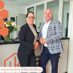 Thorsten Kotzur von Kotzur Immobilien Aachen und Maureen Hulsman von GRENSimmo Vaals stehen lächelnd nebeneinander und präsentieren ihre neue Immobilien-Kooperation für das Dreiländereck. Professionelles Teambild der beiden inhabergeführten Immobilienmakler für Aachen und die Niederlande.