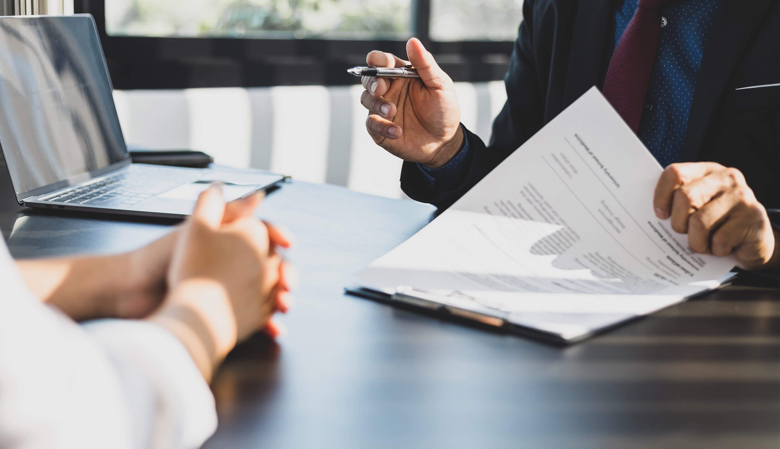 Ein Beratungsgespräch zu Vertragsunterlagen in einem Büro - Wüstenrot Immobilien
