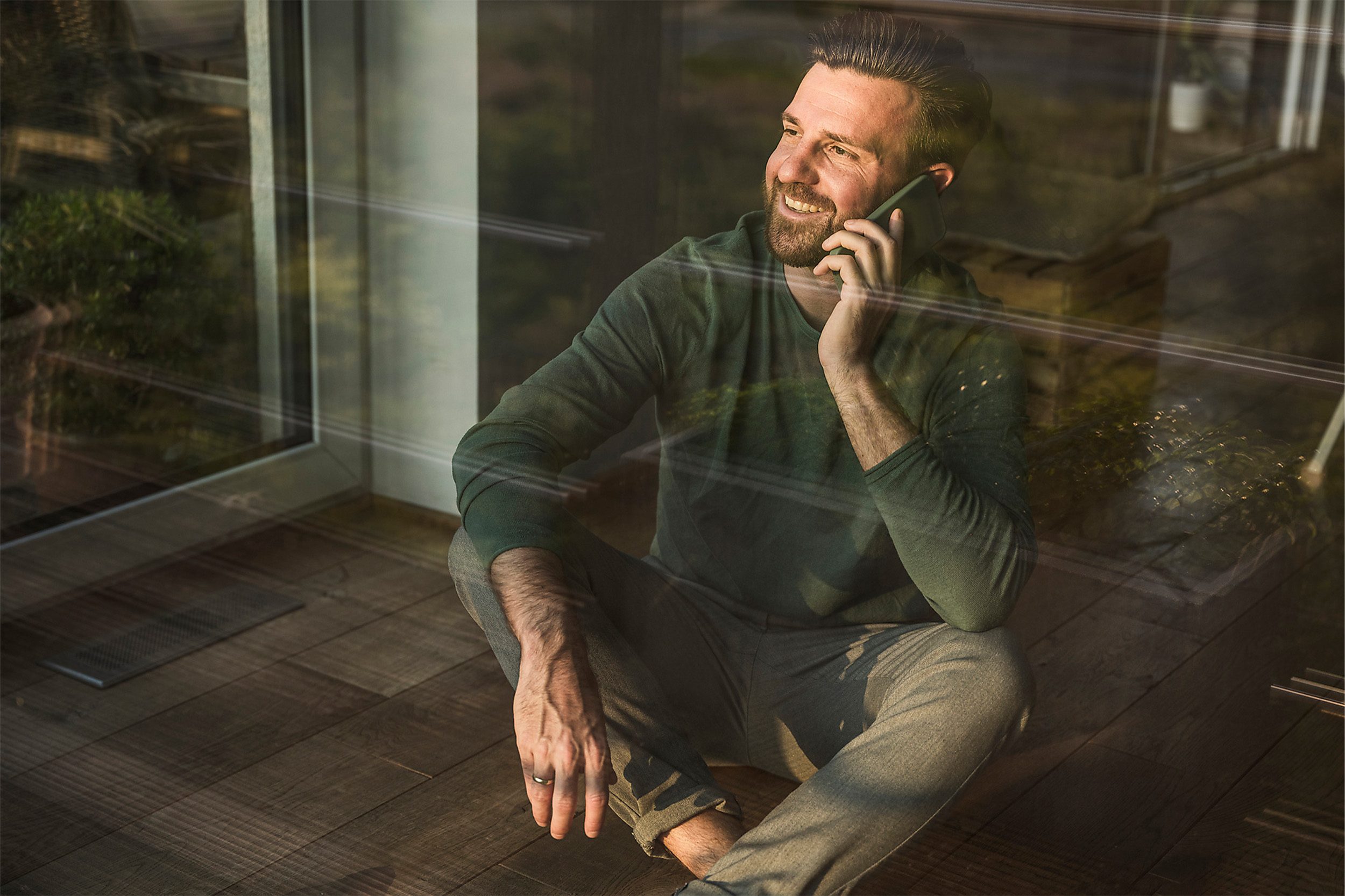 Ein Mann informiert sich am Telefon über die Kosten beim Immobilienverkauf - Wüstenrot Immobilien