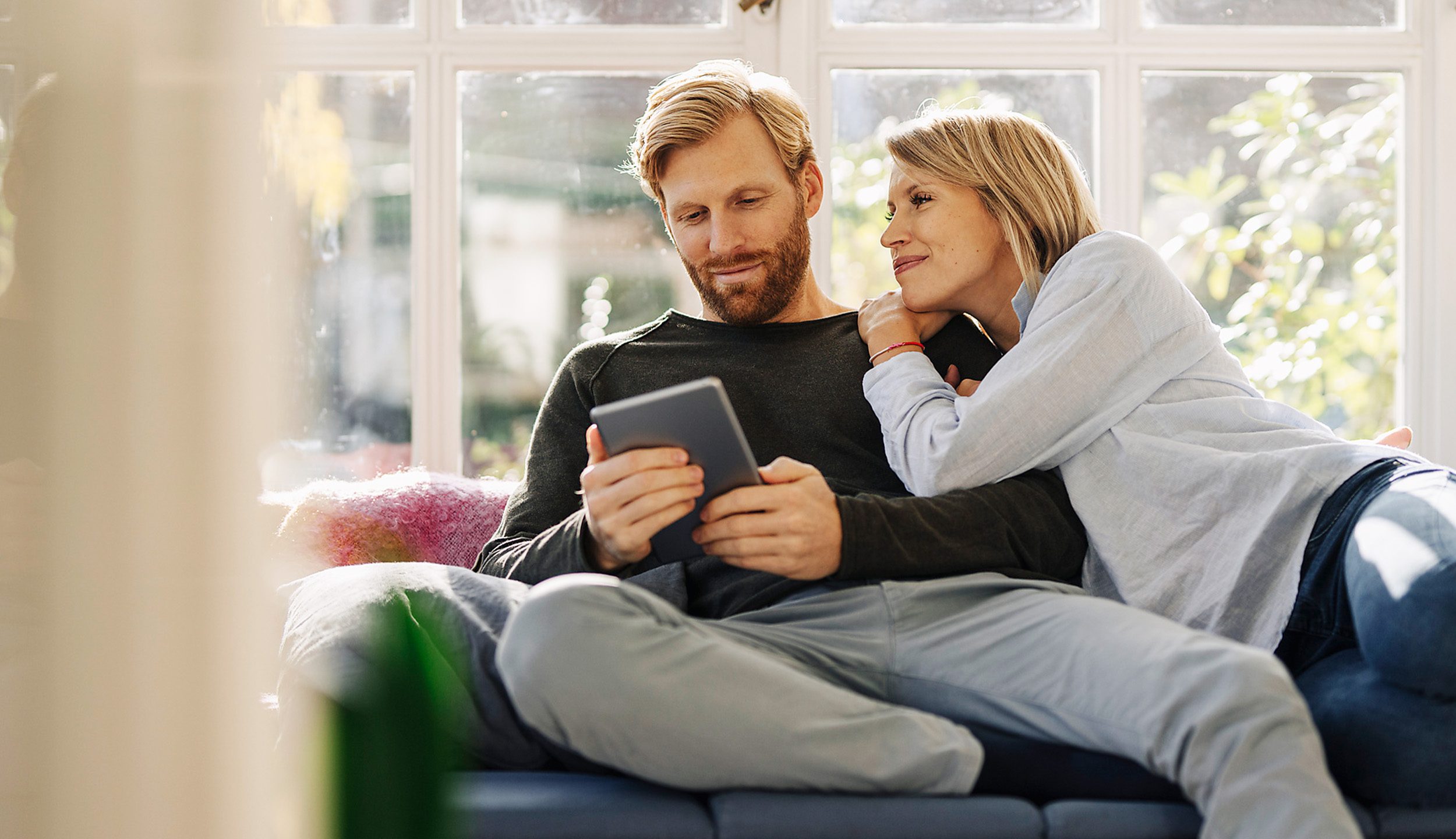 Ein Paar informiert sich online ueber den Wert ihrer Immobilie
