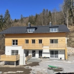 Modernes Haus mit Solarpaneelen in einer ländlichen Umgebung