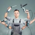 Handwerker und Hausmeister mit Elektrowerkzeugen und Handwerkzeugen bei Reparaturarbeiten in einem Haus