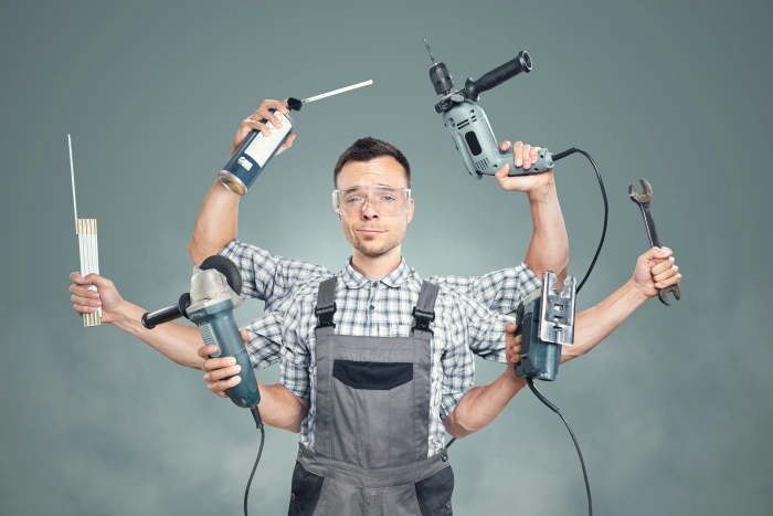 Handwerker und Hausmeister mit Elektrowerkzeugen und Handwerkzeugen bei Reparaturarbeiten in einem Haus
