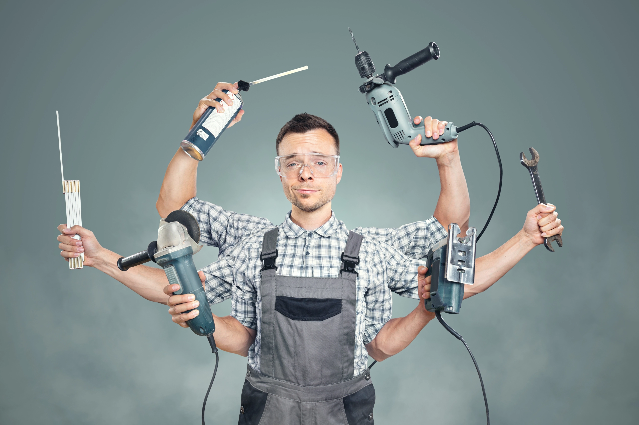 Handwerker und Hausmeister mit Elektrowerkzeugen und Handwerkzeugen bei Reparaturarbeiten in einem Haus