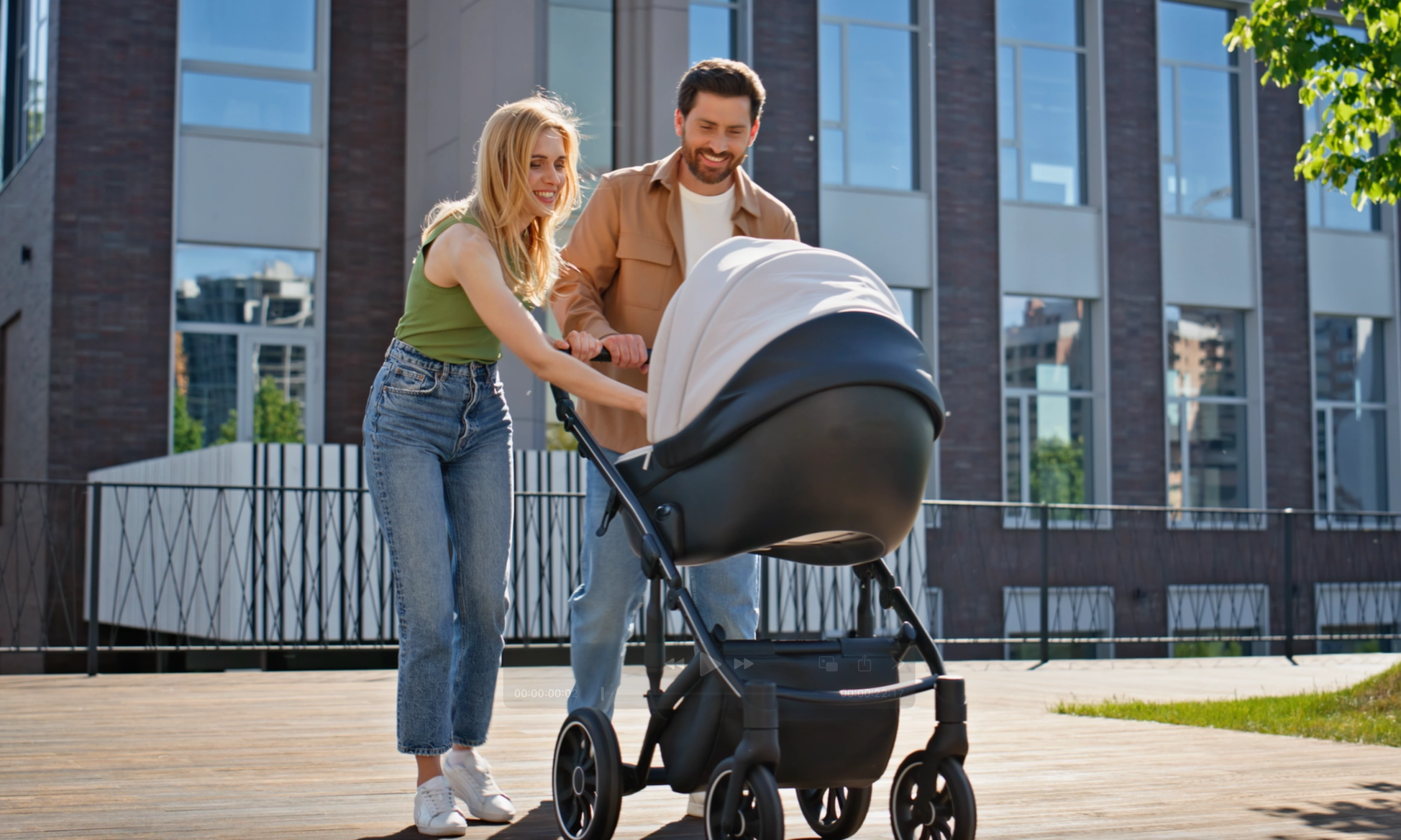 Junge Familie mit Kinderwagen in moderner Wohnanlage