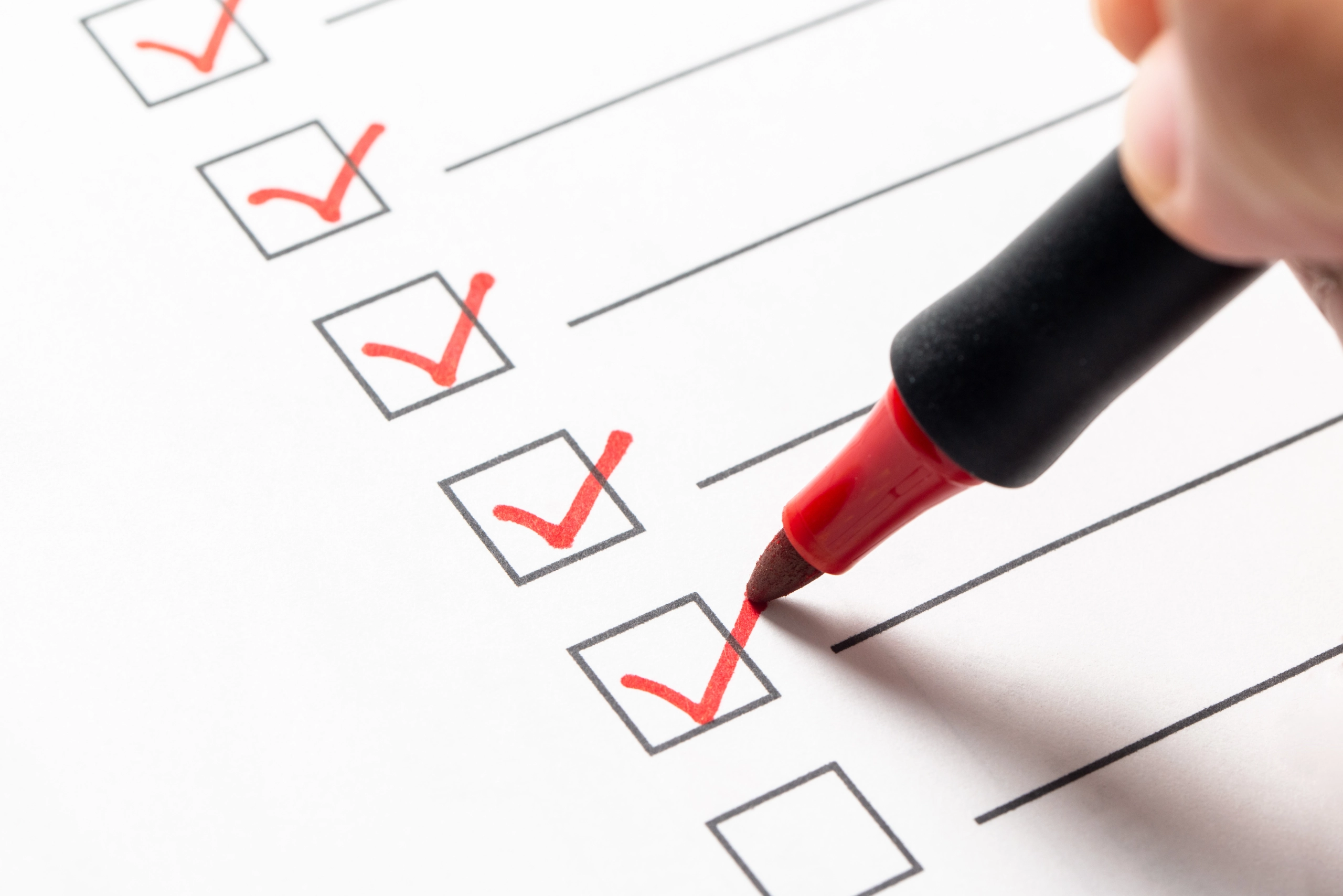 Rote Häkchen auf einer Checkliste – Symbolbild für Hausverkauf vorbereiten